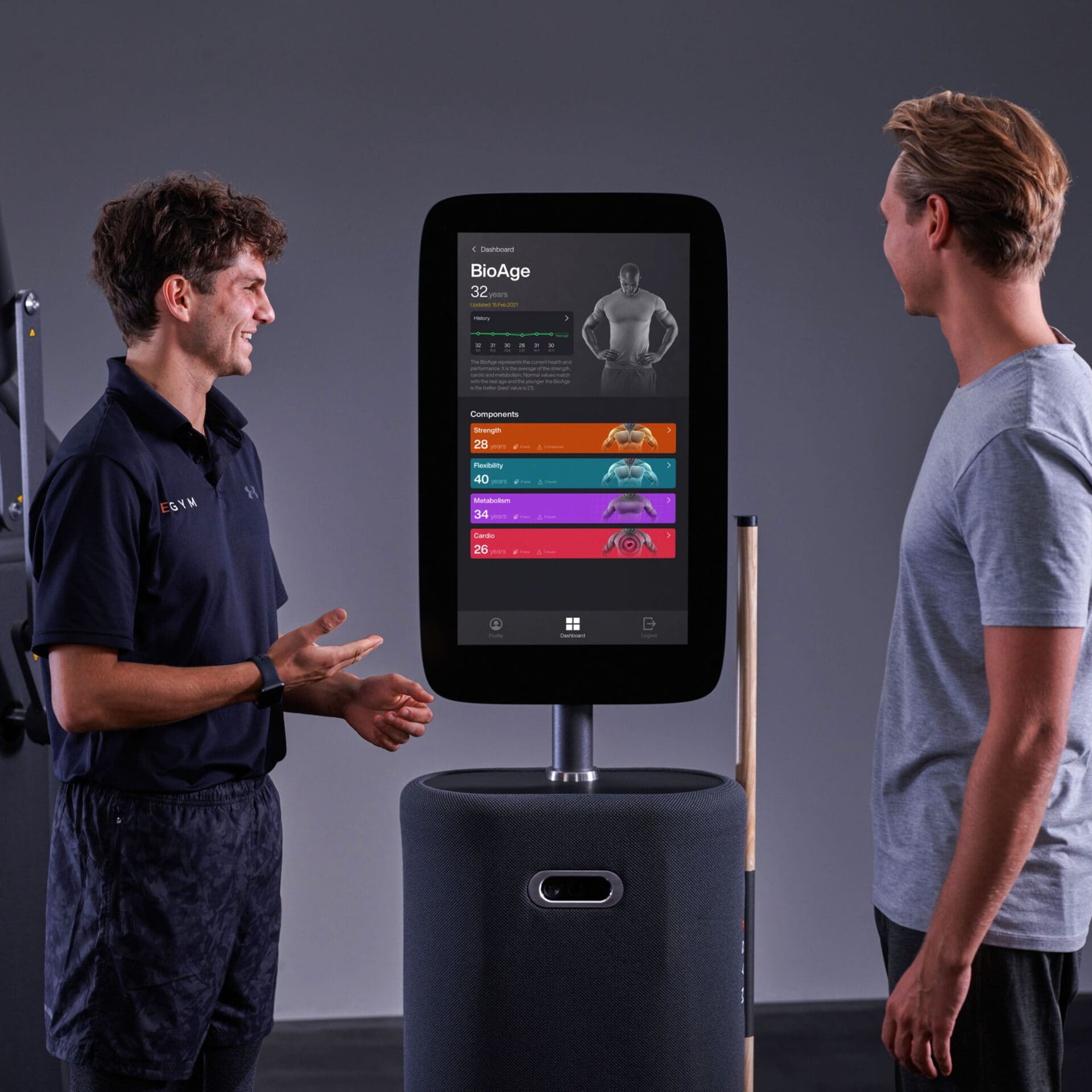Trainer bespreekt de BioAge-uitslag op het EGYM-scherm met een sporter